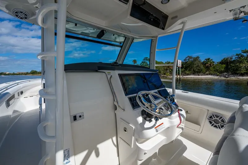  Yacht Photos Pics 2011 Boston Whaler 370 Outrage helm with steering wheel, navigation system, and coastal view.