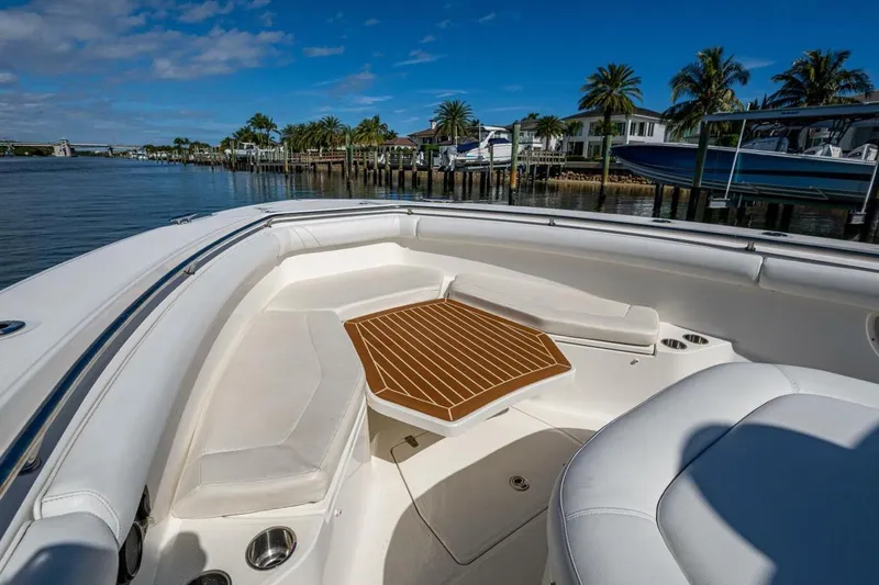  Yacht Photos Pics Boston Whaler 370 Outrage 2011 boat interior with seating and table, docked by palm trees.