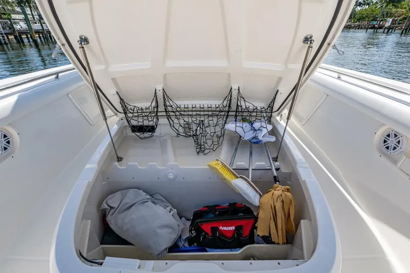  Yacht Photos Pics Open storage compartment on 2011 Boston Whaler 370 Outrage, featuring cleaning supplies and gear.
