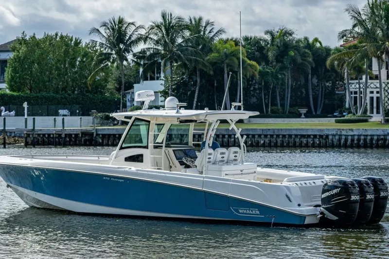  Yacht Photos Pics 2011 Boston Whaler 370 Outrage boat on water, surrounded by palm trees and waterfront homes.