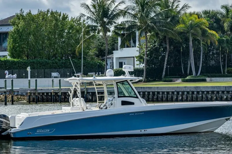  Yacht Photos Pics 2011 Boston Whaler 370 Outrage boat docked near palm trees and waterfront homes.