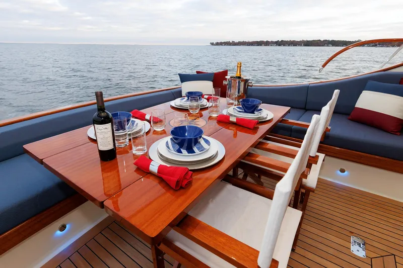 Mona Lisa Yacht Photos Pics Elegant dining setup on 2025 Vicem 58 Classic yacht, overlooking serene ocean view.