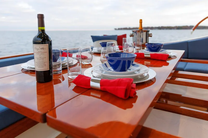 Mona Lisa Yacht Photos Pics Elegant dining setup on Vicem 58 Classic yacht, featuring wine and ocean view.