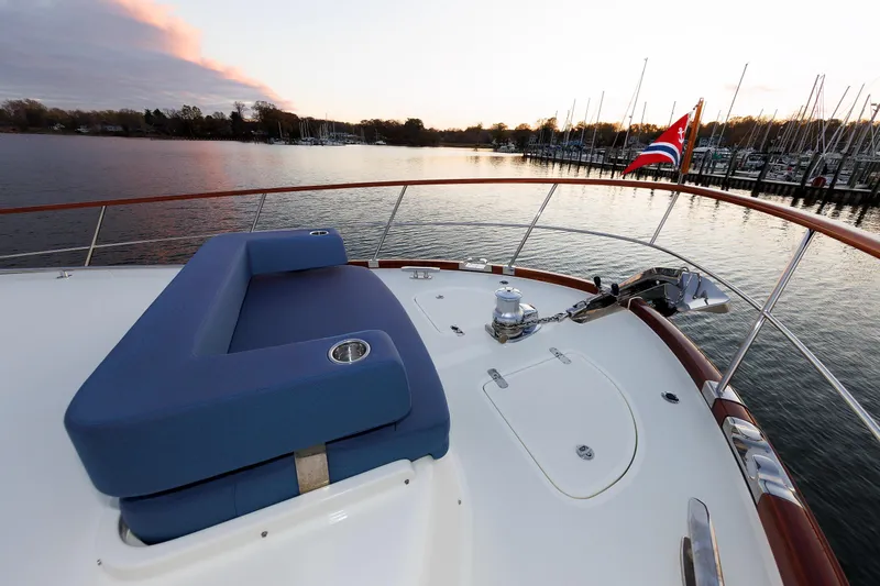 Mona Lisa Yacht Photos Pics 2025 Vicem 58 Classic yacht deck with blue seating, overlooking serene marina at sunset.