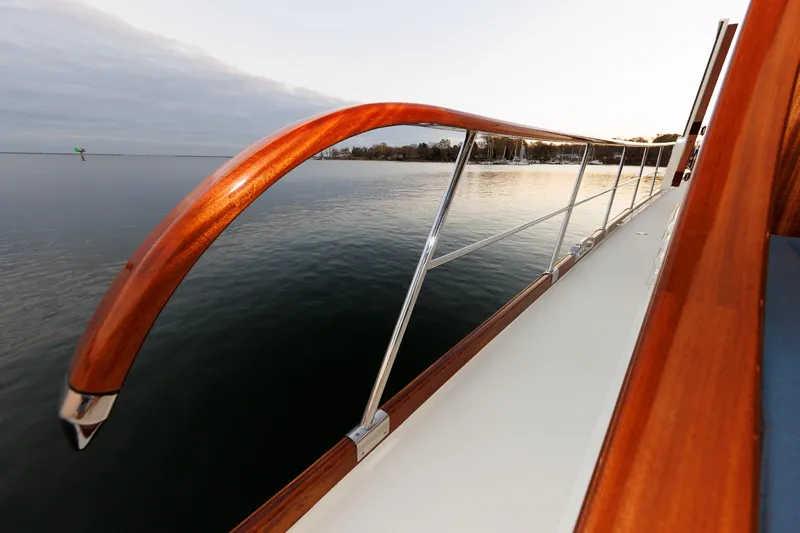 Mona Lisa Yacht Photos Pics Vicem 58 Classic 2025 yacht railing with wooden accents on calm water.
