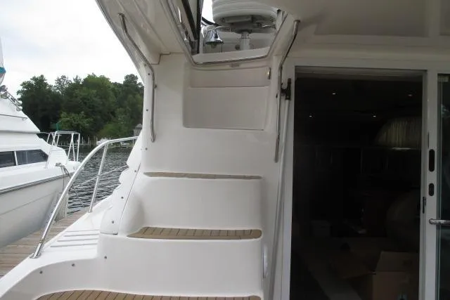 Pho-king-gross Yacht Photos Pics Staircase on 2002 Sea Ray 400 Sedan Bridge yacht, docked by a serene waterfront.
