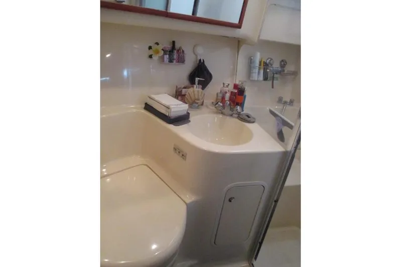 Pho-king-gross Yacht Photos Pics Bathroom interior of 2002 Sea Ray 400 Sedan Bridge yacht, featuring sink and toiletries.