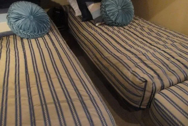 Pho-king-gross Yacht Photos Pics Interior of 2002 Sea Ray 400 Sedan Bridge with striped twin beds and blue cushions.