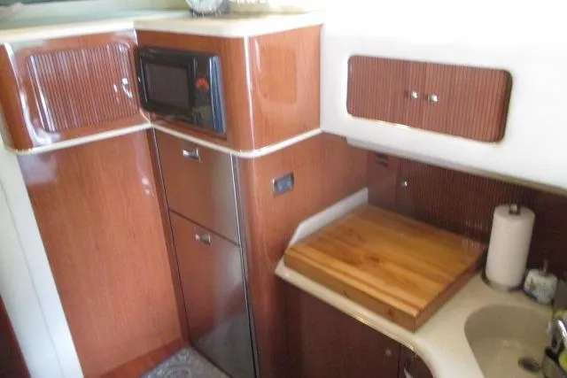 Pho-king-gross Yacht Photos Pics 2002 Sea Ray 400 Sedan Bridge kitchen with wood cabinetry, microwave, and sink.