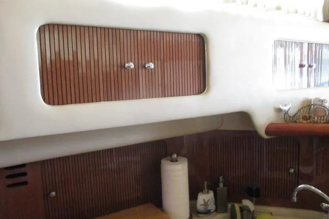 Pho-king-gross Yacht Photos Pics Interior of 2002 Sea Ray 400 Sedan Bridge yacht with wooden cabinets and kitchen sink.