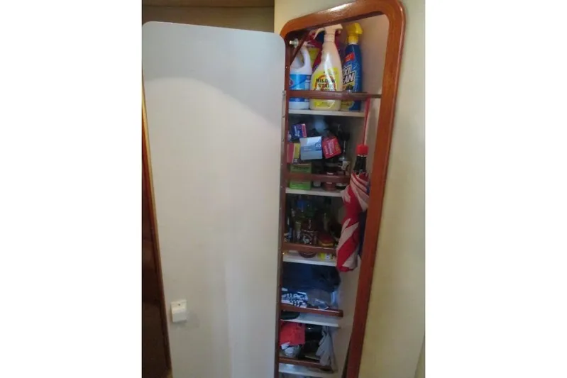 Pho-king-gross Yacht Photos Pics Storage cabinet on a 2002 Sea Ray 400 Sedan Bridge, stocked with cleaning supplies.