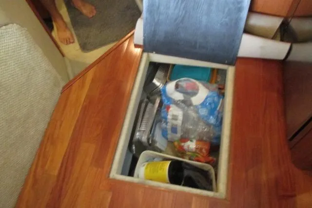 Pho-king-gross Yacht Photos Pics Storage compartment on 2002 Sea Ray 400 Sedan Bridge with various items inside.
