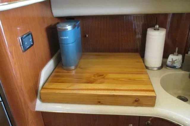 Pho-king-gross Yacht Photos Pics 2002 Sea Ray 400 Sedan Bridge kitchen with wooden countertop, coffee maker, and paper towel holder.