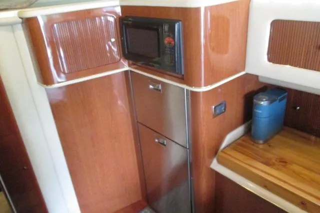 Pho-king-gross Yacht Photos Pics 2002 Sea Ray 400 Sedan Bridge kitchen with microwave and wooden cabinetry.