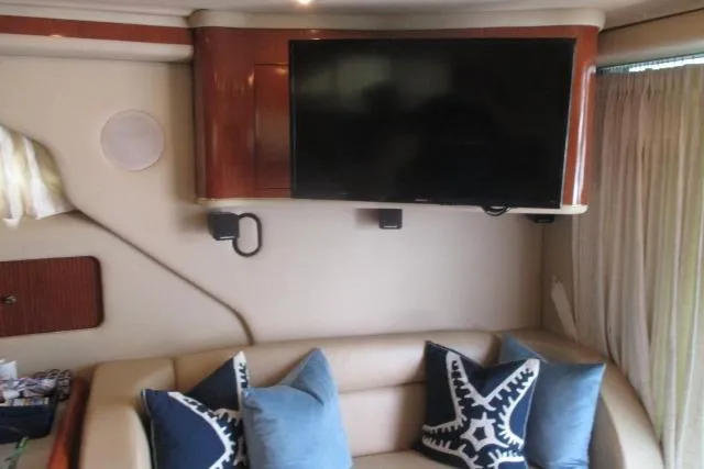 Pho-king-gross Yacht Photos Pics Interior of 2002 Sea Ray 400 Sedan Bridge with TV and decorative pillows.
