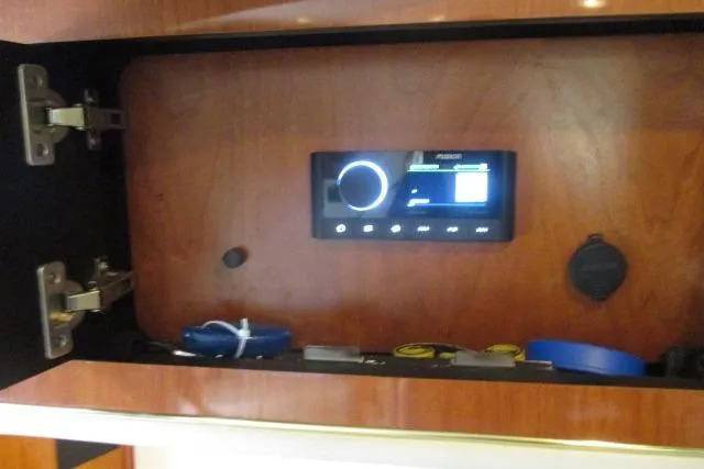 Pho-king-gross Yacht Photos Pics Audio system in a 2002 Sea Ray 400 Sedan Bridge cabinet with storage items.