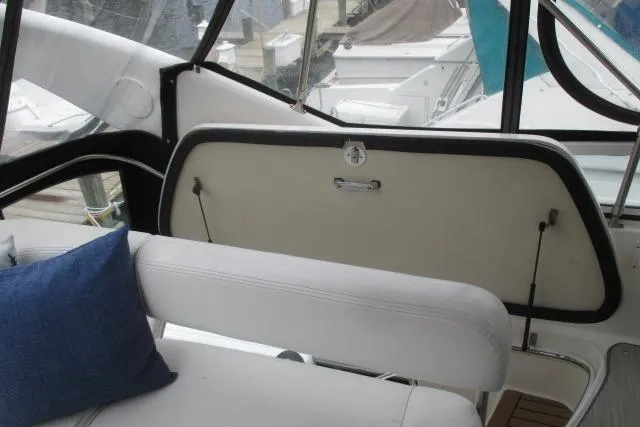 Pho-king-gross Yacht Photos Pics Interior of 2002 Sea Ray 400 Sedan Bridge with white seating and blue cushion.