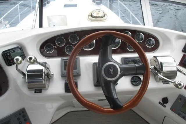Pho-king-gross Yacht Photos Pics Helm of 2002 Sea Ray 400 Sedan Bridge with wooden steering wheel and control panels.