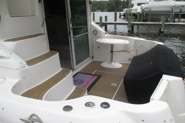 Pho-king-gross Yacht Photos Pics 2002 Sea Ray 400 Sedan Bridge yacht deck with seating and table, docked at marina.
