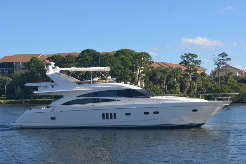  Yacht Photos Pics 2006 Princess 67 Flybridge yacht cruising on a serene waterway.