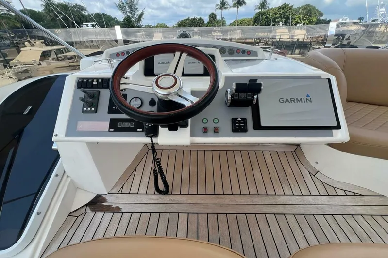  Yacht Photos Pics Helm of 2006 Princess 67 Flybridge yacht with Garmin navigation system and wooden steering wheel.
