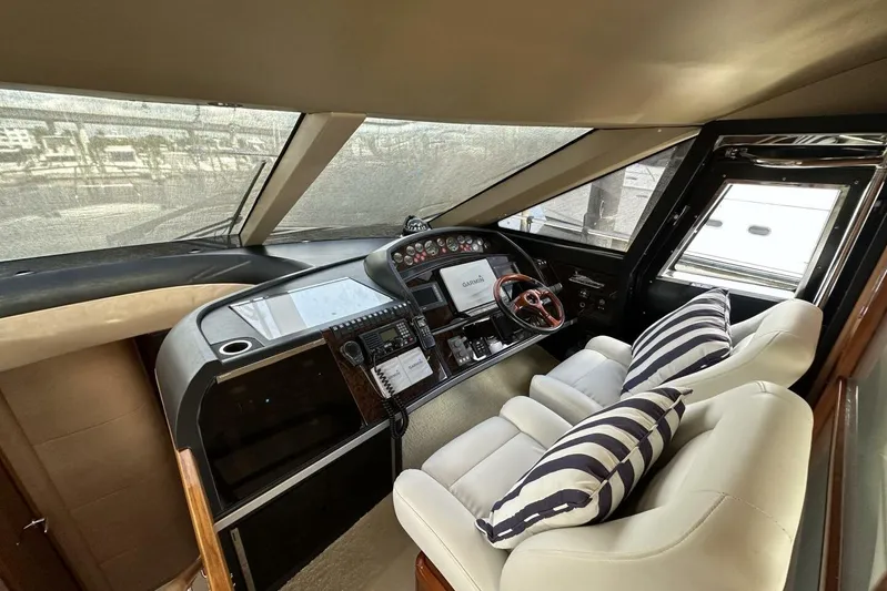 Yacht Photos Pics Interior helm of 2006 Princess 67 Flybridge yacht with modern controls and striped cushions.
