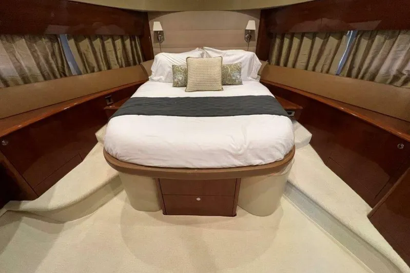  Yacht Photos Pics Luxurious bedroom interior of 2006 Princess 67 Flybridge yacht with elegant bedding and wood accents.