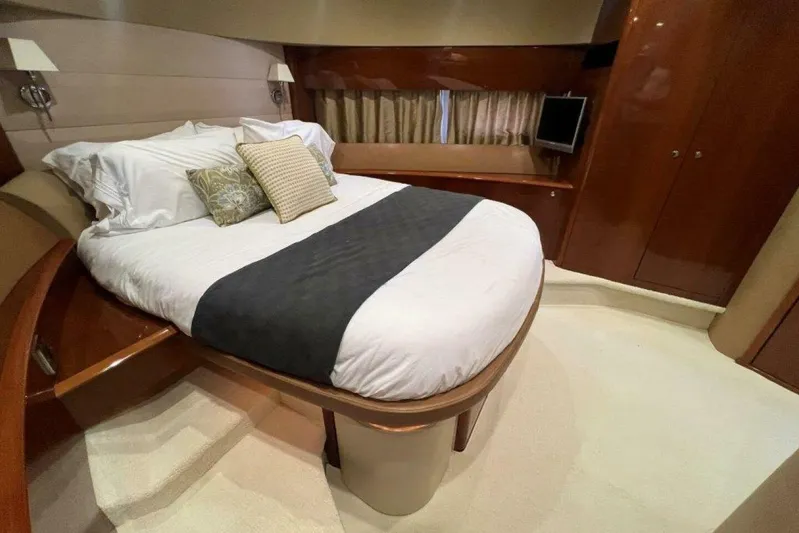  Yacht Photos Pics Luxurious bedroom interior of 2006 Princess 67 Flybridge yacht with elegant bedding and wood finishes.