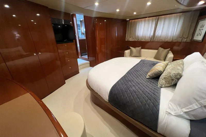  Yacht Photos Pics Luxurious bedroom interior of 2006 Princess 67 Flybridge yacht with elegant wood finishes.