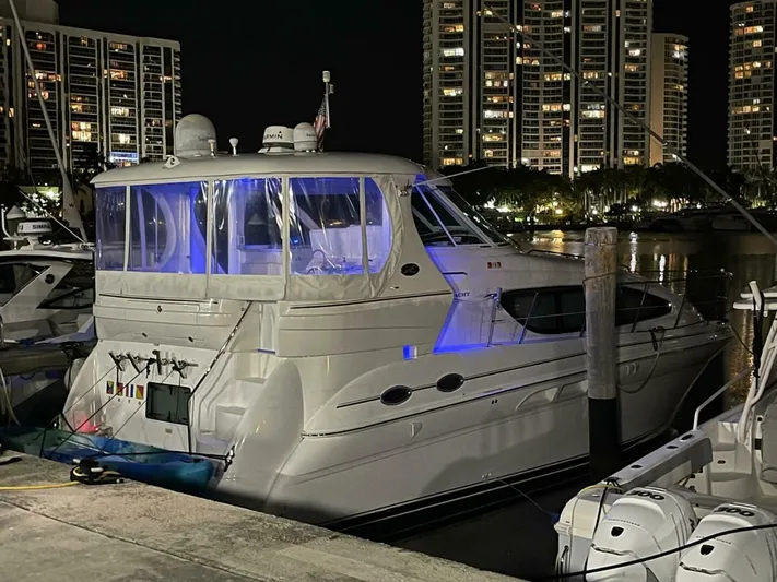 Zoto Yacht Photos Pics 2003 Sea Ray 390 Motor Yacht docked at night with city lights in background.