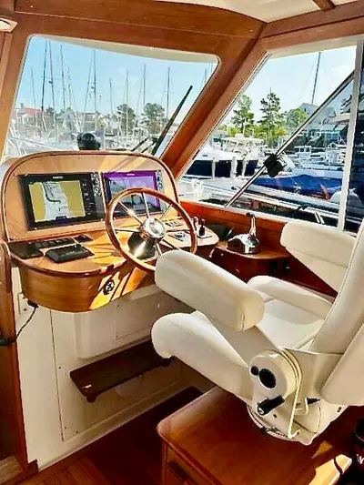 Linda Lou Yacht Photos Pics Captain's helm of 2018 Legacy 36 yacht, featuring modern navigation equipment and luxurious seating.