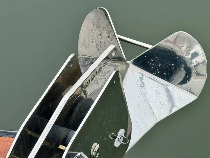 Linda Lou Yacht Photos Pics Stainless steel anchor on a 2018 Legacy 36 boat, reflecting sunlight on calm water.