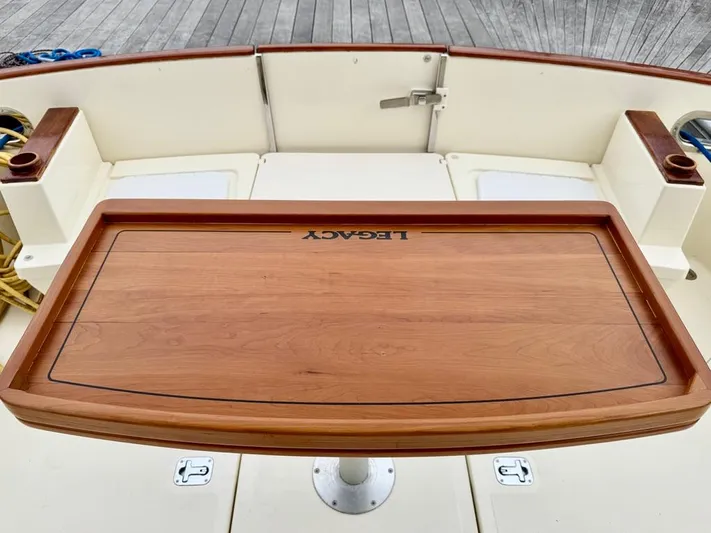 Linda Lou Yacht Photos Pics Legacy 36 boat deck with wooden table, 2018 model, docked on wooden pier.