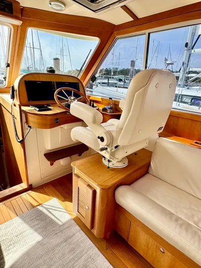 Linda Lou Yacht Photos Pics 2018 Legacy 36 yacht interior with helm, white captain's chair, and wooden accents.