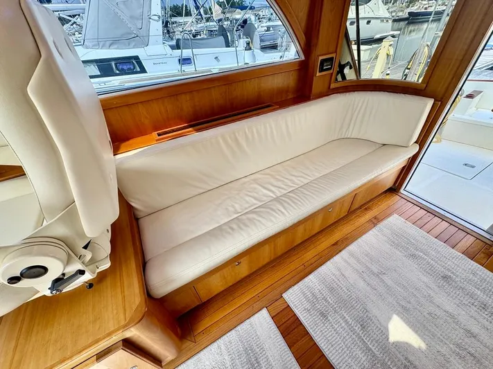Linda Lou Yacht Photos Pics Interior of 2018 Legacy 36 yacht with white cushioned seating and wooden flooring.