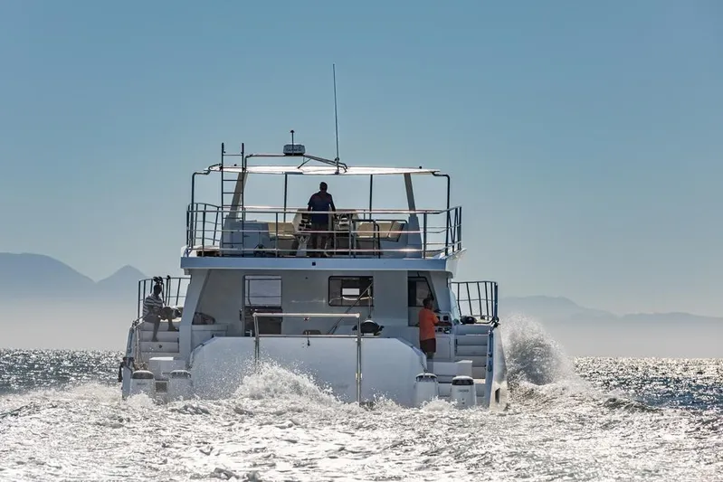 Pilar X Yacht Photos Pics 2024 Leeuwin 55 yacht cruising on open water with mountains in the background.