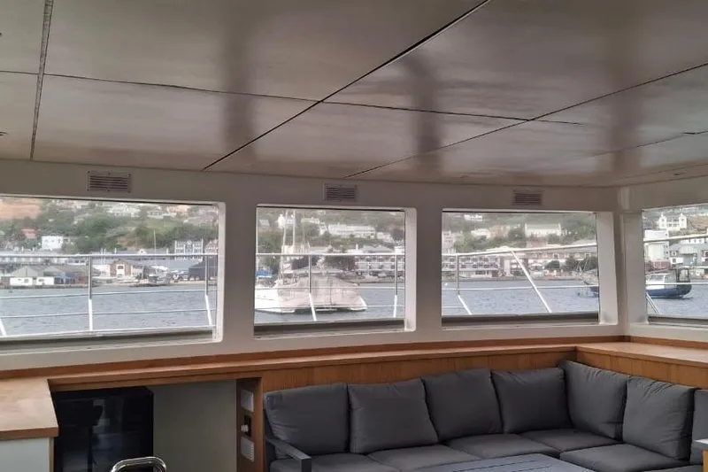 Pilar X Yacht Photos Pics Interior view of 2024 Leeuwin 55 yacht with large windows and comfortable seating.