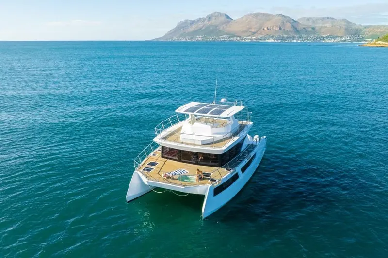 Pilar X Yacht Photos Pics Luxury 2024 Leeuwin 55 yacht cruising in clear blue waters with scenic mountain backdrop.