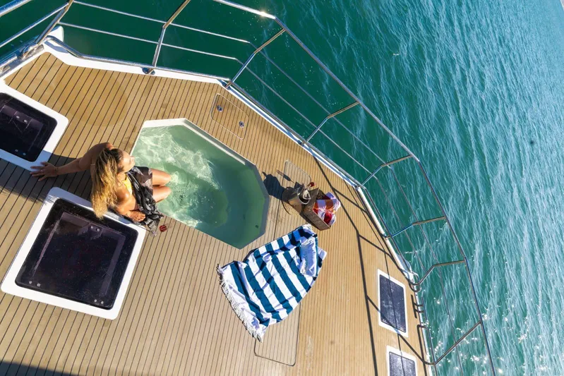 Pilar X Yacht Photos Pics Woman relaxing in jacuzzi on 2024 Leeuwin 55 yacht deck, overlooking ocean.