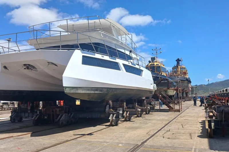 Pilar X Yacht Photos Pics 2024 Leeuwin 55 yacht in dry dock, alongside other vessels, under a clear blue sky.
