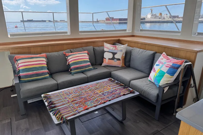 Pilar X Yacht Photos Pics Cozy lounge on Leeuwin 55 yacht, 2024 model, with colorful cushions.