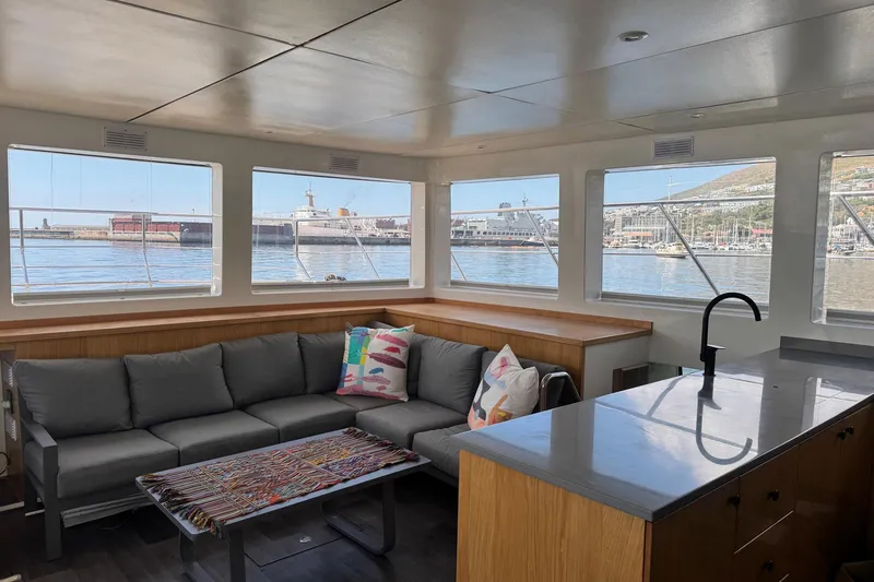 Pilar X Yacht Photos Pics Interior of Leeuwin 55 yacht, 2024, featuring sofa and harbor view.