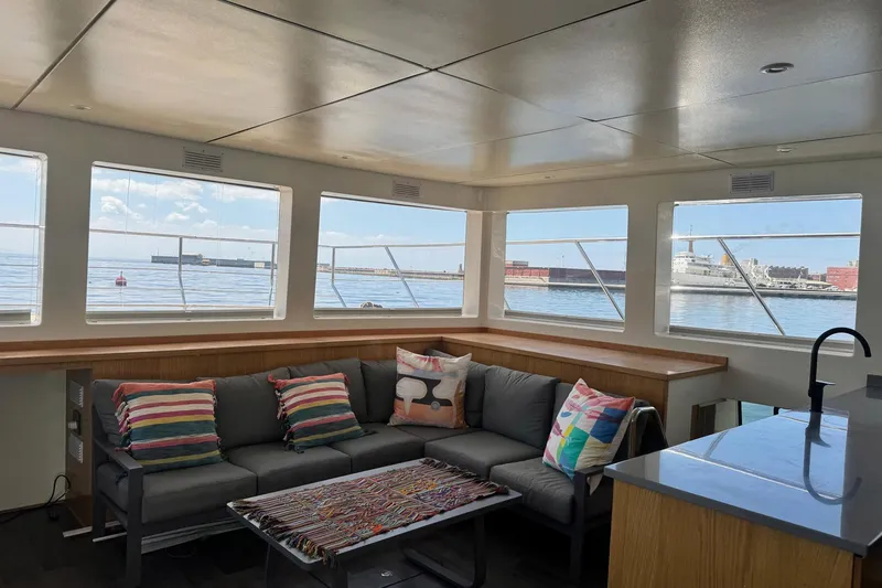 Pilar X Yacht Photos Pics Interior of Leeuwin 55 yacht, 2024, featuring sofa and ocean view.