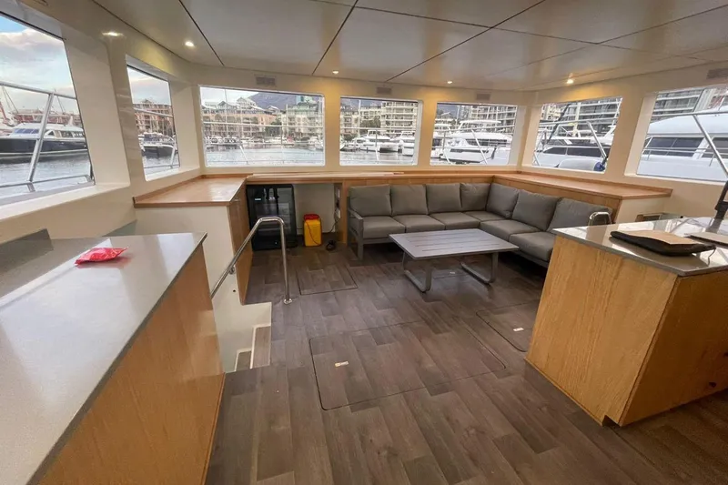 Pilar X Yacht Photos Pics Interior of Leeuwin 55 yacht, 2024 model, featuring gray sofa and harbor view.