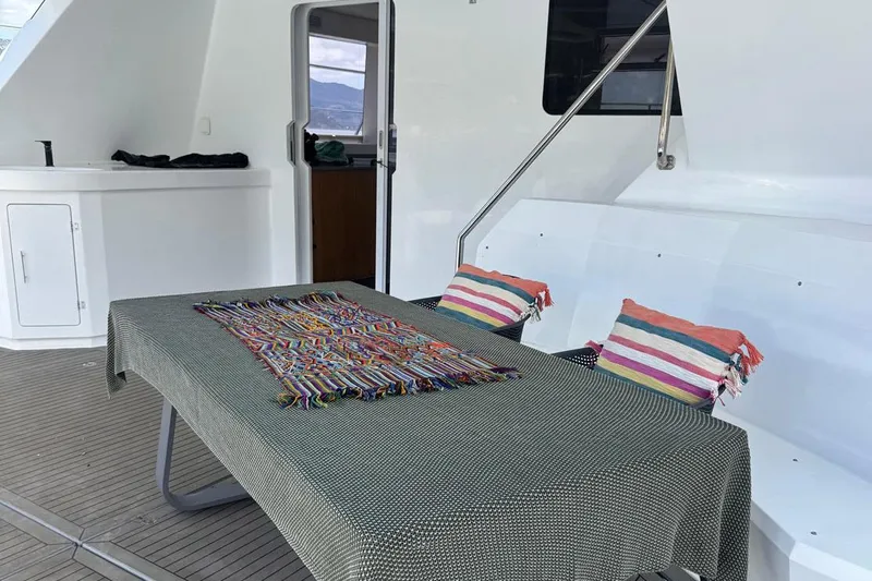 Pilar X Yacht Photos Pics Leeuwin 55 yacht deck area, 2024, featuring table and colorful cushions.