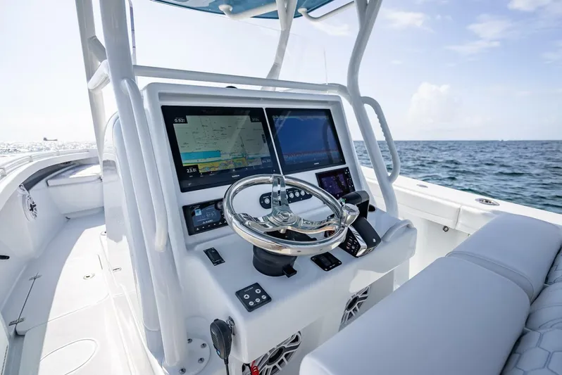 34 Offshore Yacht Photos Pics 2025 Yellowfin 34 Offshore boat dashboard with dual screens and steering wheel, ocean view.