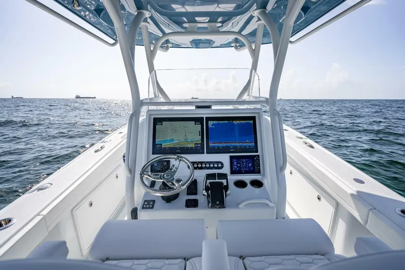 34 Offshore Yacht Photos Pics 2025 Yellowfin 34 Offshore boat dashboard with navigation screens on open sea.
