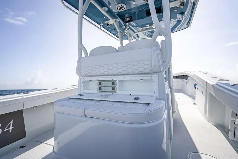34 Offshore Yacht Photos Pics 2025 Yellowfin 34 Offshore boat interior with white seating and storage, under clear blue sky.