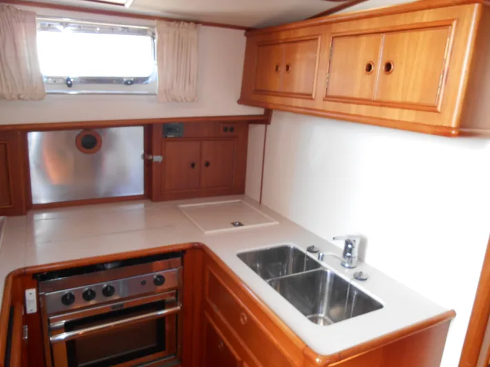 Balmy Yacht Photos Pics 1999 Grand Banks 38 Eastbay EX yacht kitchen with wood cabinetry and stainless steel sink.