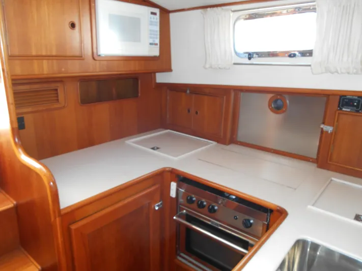 Balmy Yacht Photos Pics 1999 Grand Banks 38 Eastbay EX galley with wood cabinetry, stove, and microwave.